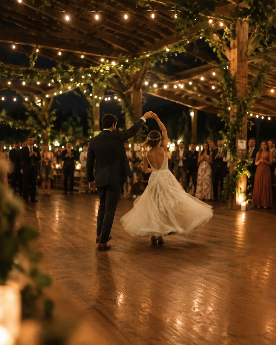 A first dance under string lights in an open barn